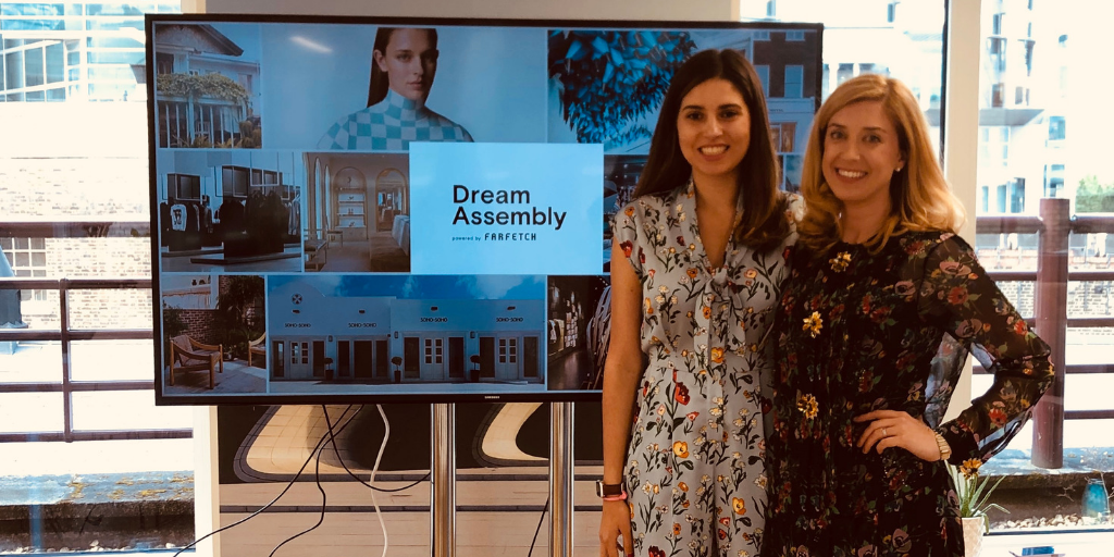 Our founder Jane Mosbacher Morris and teammate Danielle Franco posing in front of a digital presentation reading "Dream Assembly"