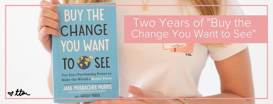 "Two Years of Buy The Change You Want To See" with a close up of our founder and author of the book, Jane, holding the book